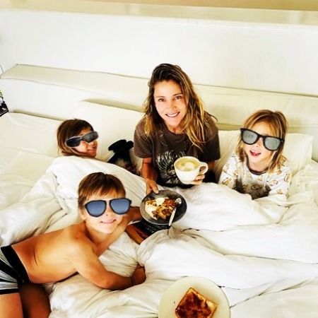 Sasha Hemsworth and his family having breakfast in a lavish bed.